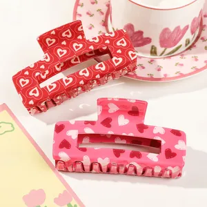 Close-up of pink and red heart pattern acrylic claw clips with non-slip teeth detail