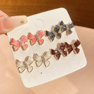Close-up of four pairs of bow-knot earrings with enamel colors and sparkling rhinestones