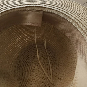 Internal view of straw sun hat featuring woven texture, sweatband and adjustable drawstring