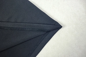 Detailed close-up of the fine knit texture and stitching on the dark navy blue maxi dress