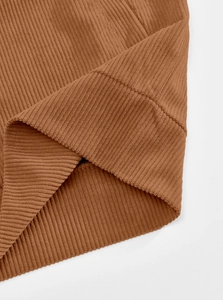 Close-up of brown corduroy fabric texture and ribbed stitching details on the jacket
