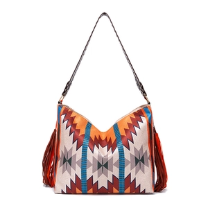 Detailed close-up of bohemian tote bag featuring geometric patterns and leather tassels