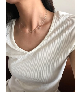Close-up of minimalist S925 sterling silver H-letter pendant necklace on a female model