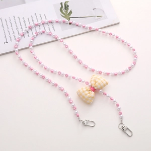 Pink and white acrylic beaded strap with yellow plaid bow and heart detail close-up