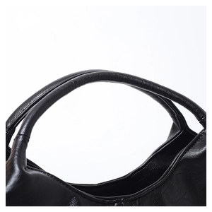 Close-up of dual round handles and soft leather texture on a black commute handbag