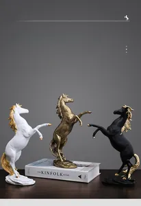 Detailed close-up of three elegant horse statues in white, gold, and black finishes