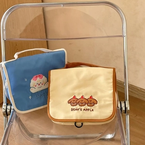 Detail of embroidered travel cosmetic bags with cute dog patterns and handle strap