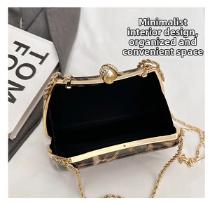 Detail of leopard print evening bag with golden chain and pearl clasp decoration