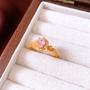 Vintage-Goldring mit rosa ovalem Stein und floralen Zirkonia-Akzenten in Nahaufnahme