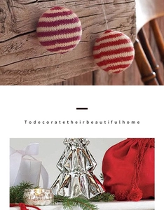 Detail of knitted Christmas ornaments, silver glass tree and red velvet gift bag decor