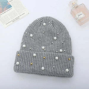Close-up of grey ribbed knit beanie featuring elegant faux pearls and metallic bead accents