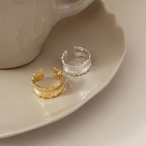 Detailed view of gold and silver irregular textured 925 sterling silver rings on a plate
