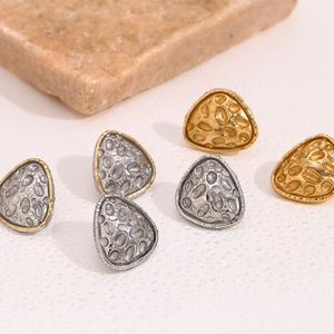 Detail of triangle stud earrings with hammered crater texture in gold and silver finish