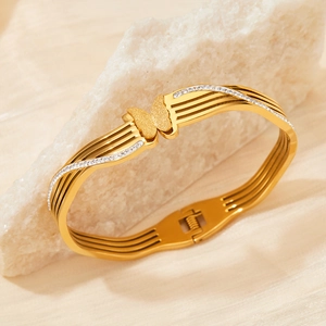 Elegant gold butterfly bangle with frosted finish and pavé crystals on stainless steel