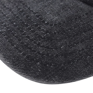 Macro shot of durable washed denim fabric and stitched seams on a black baseball cap