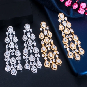 Detail of long tassel drop earrings with sparkling pear-cut cubic zirconia in gold and silver