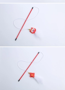 Detail of red cat wand toy with white feathers and traditional embroidered charms