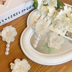 Elegant French camellia hair clip with pearls and resin petals in a vintage tray