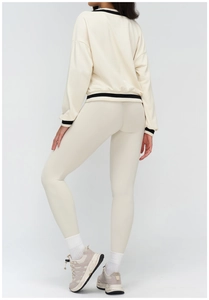 Rear view of woman in off-white sweatshirt featuring black and white striped ribbed cuffs