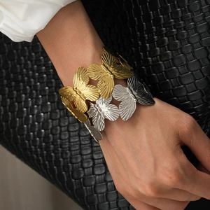 Wide butterfly motif open bangle in mixed gold and silver tones with metallic texture