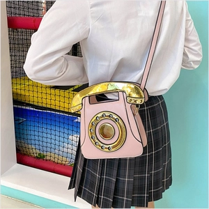Pink telephone-shaped crossbody bag featuring golden dial and retro creative design