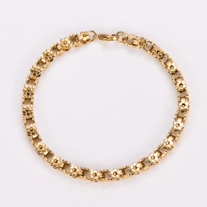 Macro shot of 18K gold plated stainless steel bracelet with floral links and lobster clasp