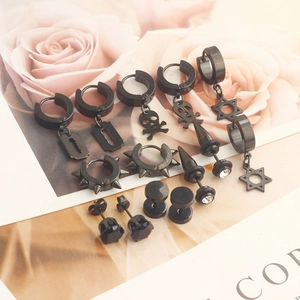 Detail of 7 pairs of black punk earrings featuring skull, blade and star studs on a floral background