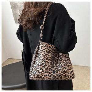 Detail of large leopard print tote bag featuring a knotted strap on model shoulder
