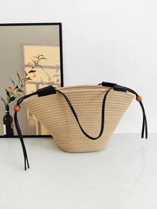 Minimalist beige woven rope tote bag with black leather straps and decorative wooden beads