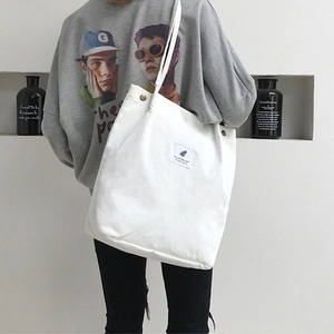 White canvas tote bag with large capacity featuring vintage buttons and leaf patch logo