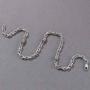 Detailed close-up of a men's stainless steel curb chain necklace with spiral metal accents