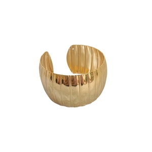 Golden wide cuff bracelet with vertical hammered texture in minimalist geometric design