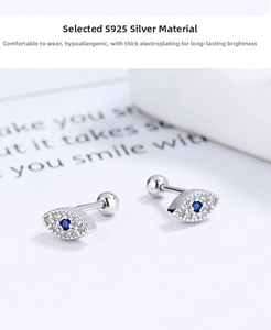 Macro shot of 925 sterling silver evil eye stud earrings with blue gemstone and white zircon