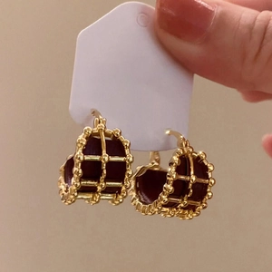 Gold-plated C-shaped hoop earrings with beaded edges and dark red leather lining