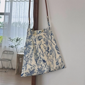 Detail of vintage blue floral canvas bag with slim brown leather shoulder strap