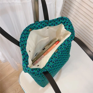 Detail view of cotton tote bag interior with green floral pattern and magnetic buckle