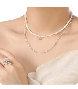 Close-up of double-layer freshwater pearl necklace with silver bead chain and floral ring