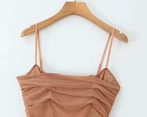 Détails d'un caraco marron en tulle avec plis élégants sur un cintre en bois