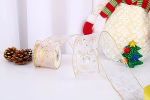 Close-up of white sheer Christmas ribbon with gold and silver snowflake patterns