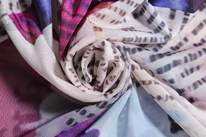 Close-up of sheer mesh fabric featuring a vibrant purple and blue abstract print
