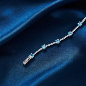 Détail du bracelet en argent S925 avec zircons bleus carrés sur tissu en soie bleue