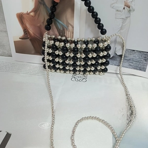 Macro shot of silver beaded handbag with checkered pattern and long crossbody chain