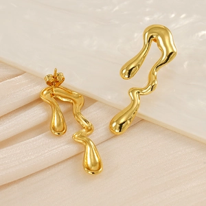 Detailed view of irregular 18K gold plated teardrop earrings on white silk
