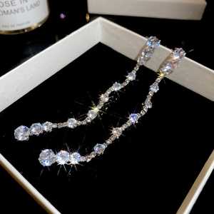 Macro shot of silver tassel earrings with zircon stones in a premium velvet gift box