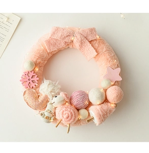 Pink wool felt Christmas wreath with a cozy snowman doll and warm LED string lights