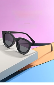 Detail of round matte black kids sunglasses on colorful geometric background