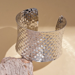 Macro shot of silver woven texture detail on wide open cuff geometric metal bracelet