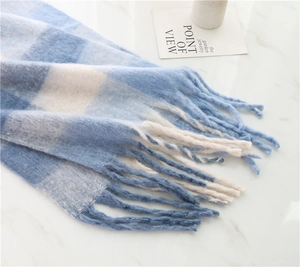 Close-up of blue and white plaid scarf with fluffy texture and fringed tassels