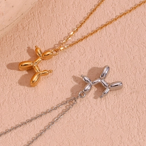 Detail of 3D balloon dog pendants in gold and silver finish with fine chain necklaces