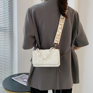 White quilted crossbody bag with stylish wide jacquard strap and acrylic chain detail